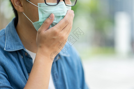 城市里佩戴口罩防止污染的男性特写图片