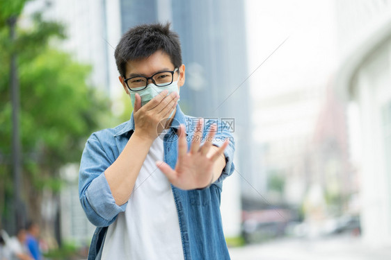 城市里佩戴口罩防止污染的男性形象图片