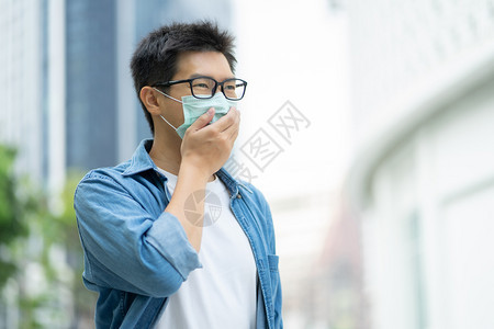 城市里佩戴口罩防止污染的男性图片