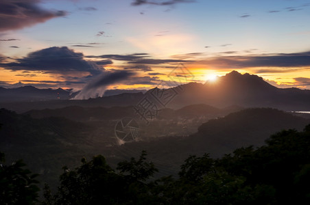 太阳冒险平静的山上美丽日落鲜艳乌云与天空在雨起雾后梅莫图片