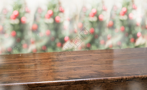 复制含有抽象模糊的圣诞树红色装饰舞会和雪落背景的木板桌顶上面有抽象模糊的圣诞树红装饰球和雪秋幕背景带有bokeh灯光冬假日背景挂图片