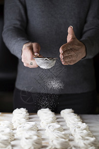 工作小雨在糕点店厨房的糖果里制棉花糖的过程是把主厨手紧一点在餐饮店里用金属筛子喷洒的微粒和粉末糖来配制棉花年轻的图片