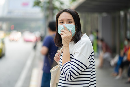 户外戴口罩防止污染的女性图片