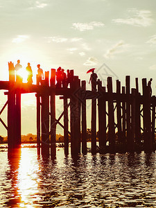 柚木美丽的缅甸日落时分在UBein桥上行走的人休光片图片