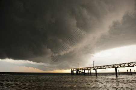 力量落下溅起巨大的黑风暴云聚集起来人们在码头上钓鱼图片