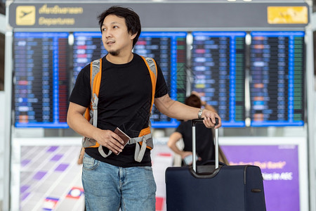 曼谷超过在现代机场旅行和运输概念的飞行信息屏幕登入飞行信息屏幕时有护照行李的亚洲旅者在飞板上站立机牌的亚洲旅行者肖像朋友们图片