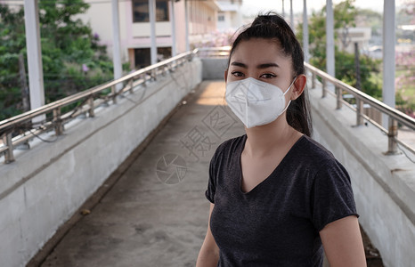 街道流行病医疗的一名黑人衬衫女站在穿戴呼吸器N95防毒面具的黑衬衫女面前以保护免受空气呼吸道疾病的影响因为甲型流感在路上染布满了图片