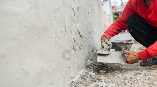 水泥房改进工作程建筑地房用墙上石膏水泥的工人手印背景