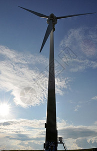 风力涡轮机作为替代能源对抗蓝云天空和明太阳活力绿色植物图片