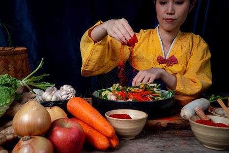 筷子身穿韩国传统服装的亚洲妇女汉博克正在混合新鲜搅拌机和基姆奇成分配有盐大蒜高清菜新鲜蔬等成分有机的辣椒图片