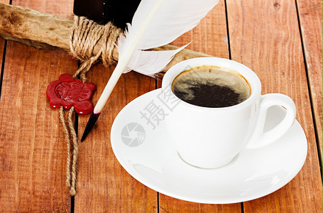 咖啡杯木制背景上加根笔和墨水卷轴早晨芳香木制的图片