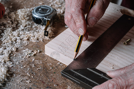 统治者木匠用铅笔和金属方块在桌子上做测量承包商木工图片