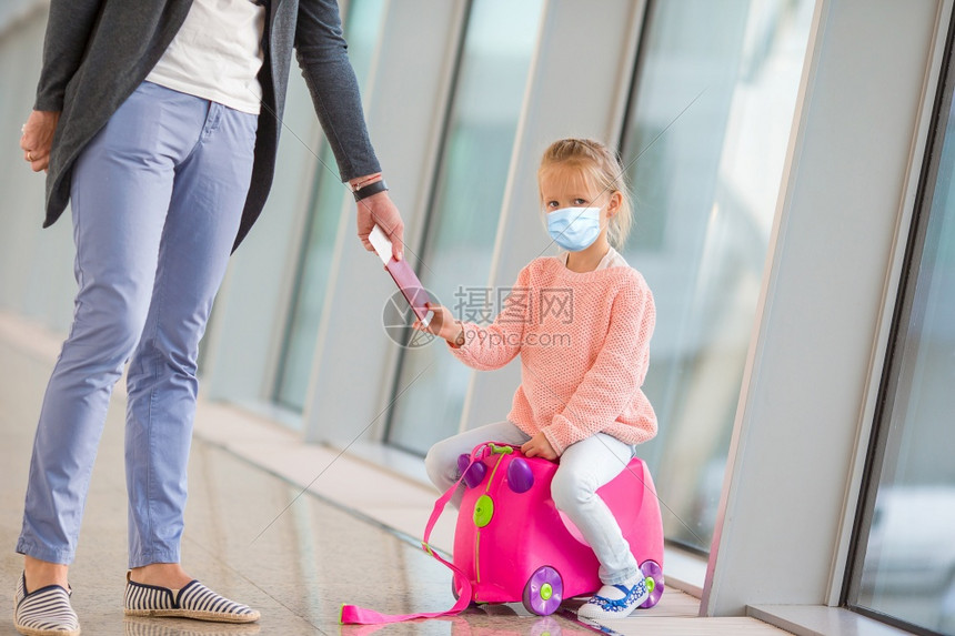 到达有外科面具的小可爱孩在国际机场面临保护父亲和女儿在机场候站有登牌准备放假小孩在机场等登的小孩小孩子在机场等着登室内飞图片