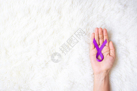 手拿紫色丝带预防癌症概念图片