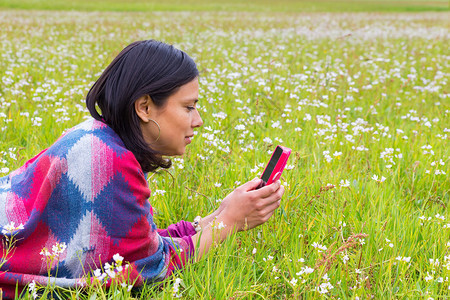 说谎的哥伦比亚女人在草地用手机打电话信息短接触图片