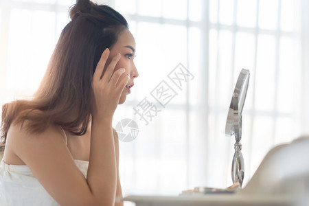 美貌女孩在化妆和触摸脸容的漂亮女孩年轻美丽的亚洲女人在镜中的Acne穿着皮肤美容学护理美容疗漂亮的水分过敏图片