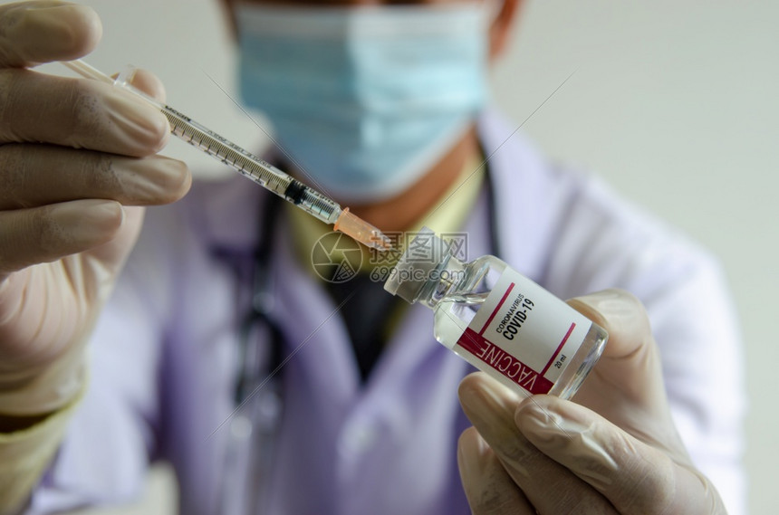 药物疫苗接种水平的戴手套医生持有注射器和疫苗瓶Vaccine抗冠状或COVID19图片