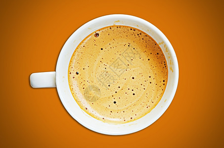 咖啡店芳香气卡布奇诺咖啡杯和橙色背景的豆子图片