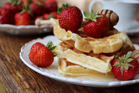 罐水果小吃比利时华夫饼鲜莓草蜂蜜和卡布奇诺咖啡用于早餐的比利时华芙饼新鲜果莓草蜂蜜和卡布奇诺咖啡图片