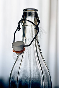 最佳白色的玻璃瓶和铁丝保险套锁在窗前用白帘遮住的陶瓷阻塞器表扣图片