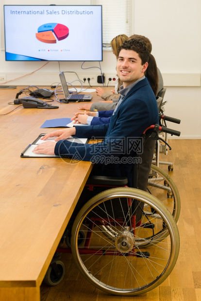 白种人障碍一名坐在轮椅上的男人与办公室环境的同事举行数字屏幕会议这名男子的肖像可能是一家新开办公司可能是一个电子屏幕种图片