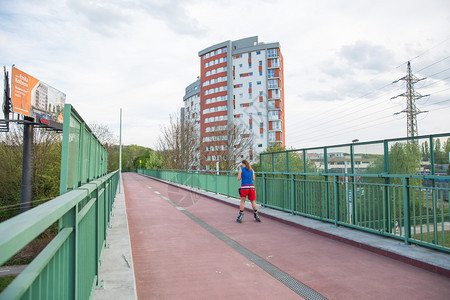 人们滚轴男子在滑冰鞋市街上有行人桥上的建筑物旅行照片2019年4月6日假期图片