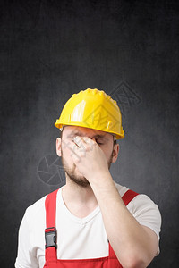 身戴黄色硬帽的建筑工人疲劳遮盖他的脸部一名疲惫建筑工人的肖像舍纳塔根服务制图片