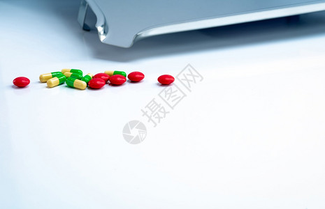 红圆制糖涂层药片和绿色黄柳胶囊白桌上有不锈钢药品托盘剂学概念制业用产品保健和药物白色的工业医疗图片