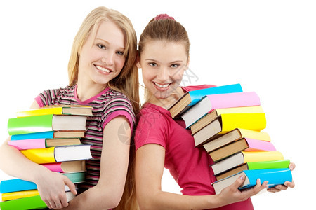 微笑的女学生携带着许多关于白背景的丰富多彩书籍负担过重颜色白的图片
