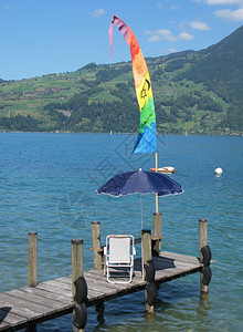 湖边季节秋天瑞士Thun湖木制码头的椅子和伞图片