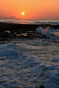黎明晚上美丽的夏天日落在海滩上惊人的景色与海浪和太阳反射背景假期和度旅行的背景希腊克里特岛地平线图片