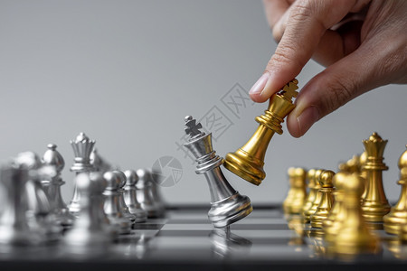 帕努瓦团队在棋盘竞争战略成功管理商业规划中断和领导力概念期间商人用手搬运金牌象棋王人物和格斗士或对手的实战人数木板图片