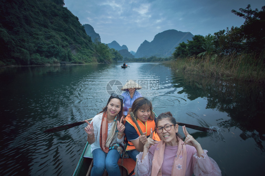 女微笑在宁宾河最受欢迎的游览目地vietnam面对快乐的情绪航行船帆上喀斯特图片