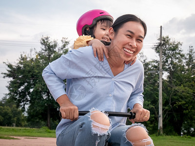 骑术周末女快乐的母亲享受愉快骑婴儿自行车和可爱的女儿一起在夏季公园玩耍家庭在度假时共空闲间图片