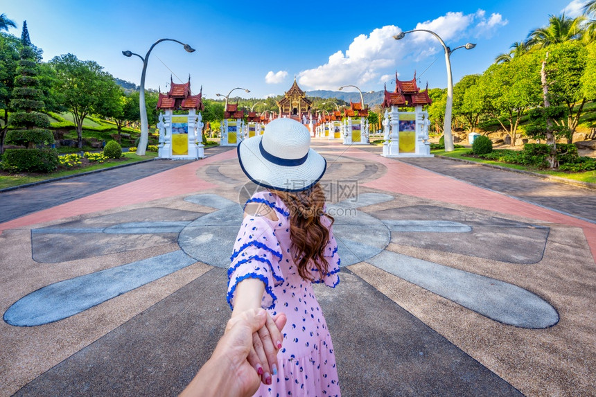 著名的花园拉查普鲁克女观光客手握着芒尔斯柯的手并带领他到泰国清迈市皇家花旗大教堂RoyalFloraratchaphruek北塔图片