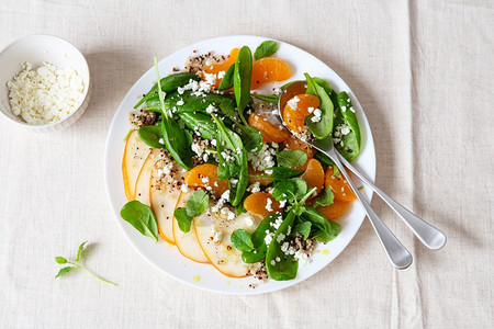 桌子配有梨橙和Ricotta健康餐饮的菠菜和quinoa沙拉基于植物的菜盘GreenVegan活食谱树叶简单的图片