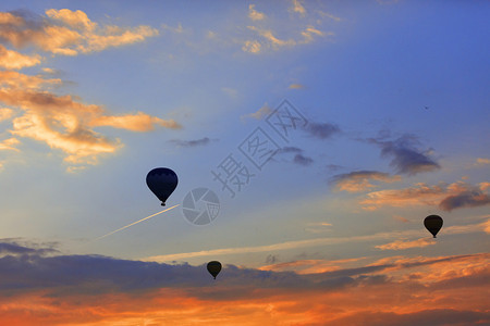 日出清晨在空中高飞行的机背景下将游客带入蓝色天空的气球休眠机使游客登上烈红云空的蓝天月光下的气球休眠机其背景是早晨的天空其中含有图片