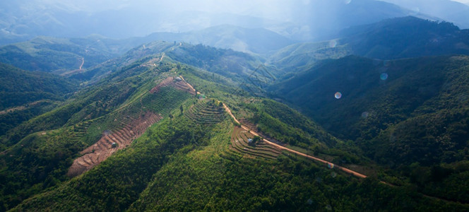 闪亮的镜片如画在雨季对山土路和稻田梯进行空中观察阳光通过云层闪耀而照射到山区南缅甸的农村景点摘要镜头照明图片