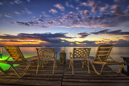 空甲板椅子和木制码头的椅子等待海边日出水晚上暮图片