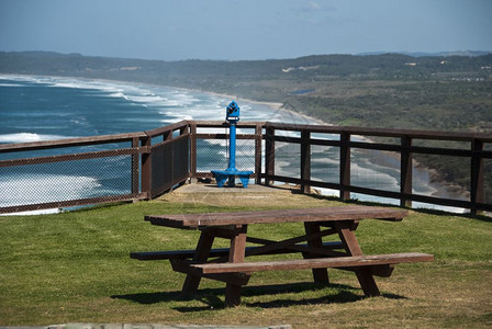 黄昏飞灯塔在拜伦湾美好海滨情景之上的一席长椅图片