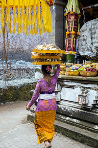 印度尼西亚巴厘2019年月日妇女头顶上水果篮在寺庙献祭结石佛普鲁图片