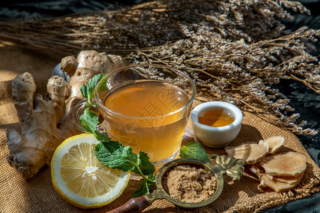 喝茶热姜汁加柠檬和薄荷根小片姜汁含红糖和蜂蜜盛满棕色糖和麻布的蜂蜜热姜汁可以帮助身体变暖健康饮用自然图片