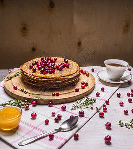 甜美的煎饼果子和一杯茶蜂蜜勺子放在木制生锈背景上早餐覆盆子传统的图片