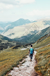 最佳带着背包在山上徒步旅行的年轻人积极度过暑假渡观看少年从山顶下到脚沿坡谷走下来的青少年沿着公园图片