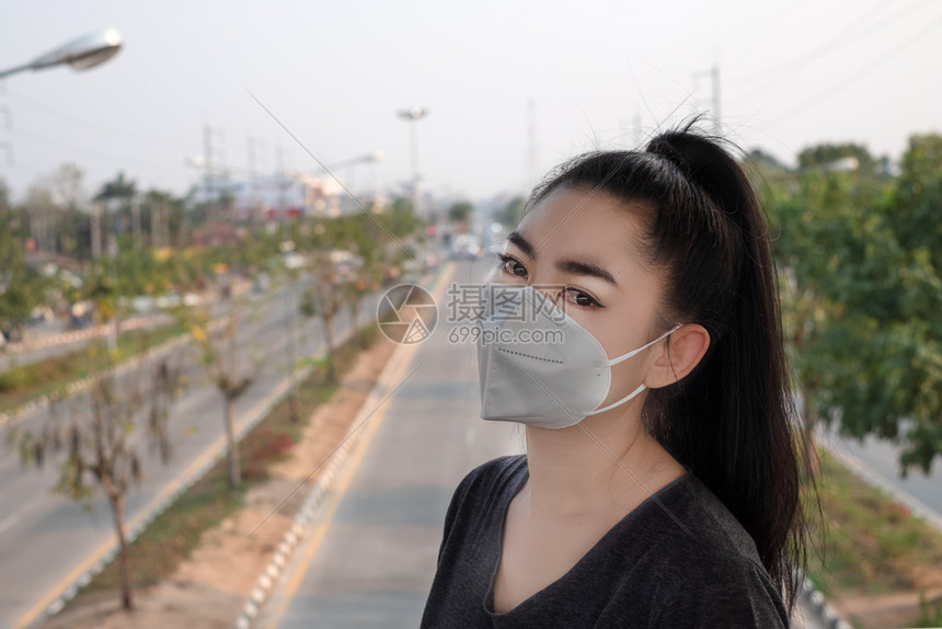 新冠医疗的流行一名黑人衬衫女站在穿戴呼吸器N95防毒面具的黑衬衫女面前以保护免受空气呼吸道疾病的影响因为甲型流感在路上染布满了本图片