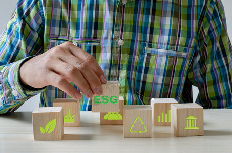 组织增长手握着木立方板象征着ESG概念的绿色标志象形物ESG投资可持续的信社会图片