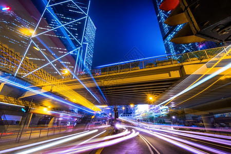 模糊洪香港街对面的摩天大楼和城市交通灯光照亮的未来夜市风景晚图片