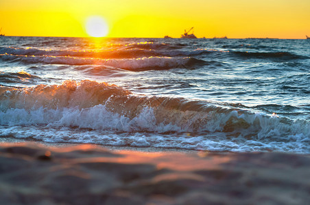 黄色的云在波罗海浪冲和辉煌日出时海边的红黄夕阳天气图片