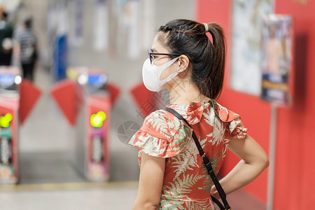 地铁里戴口罩预防流感的女性图片