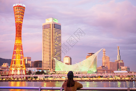 女士在大阪附近的神户港旅行年轻女快乐亚洲旅行者在日落里程碑处看着美丽的现代建筑在日本兵库县神户市旅游景点很受青春欢迎终端场景图片